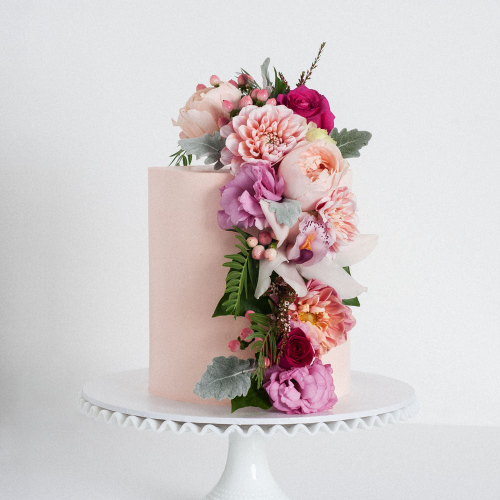 Pink buttercream cake with a flower cascade