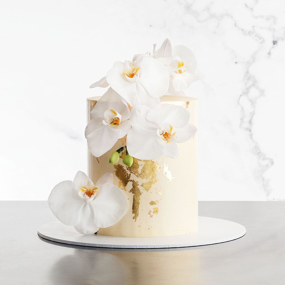 Natural buttercream cake with gold leaf and white flowers