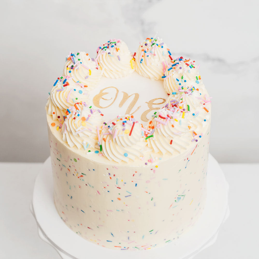 Natural buttercream cake with piping, sprinkles and number plaque