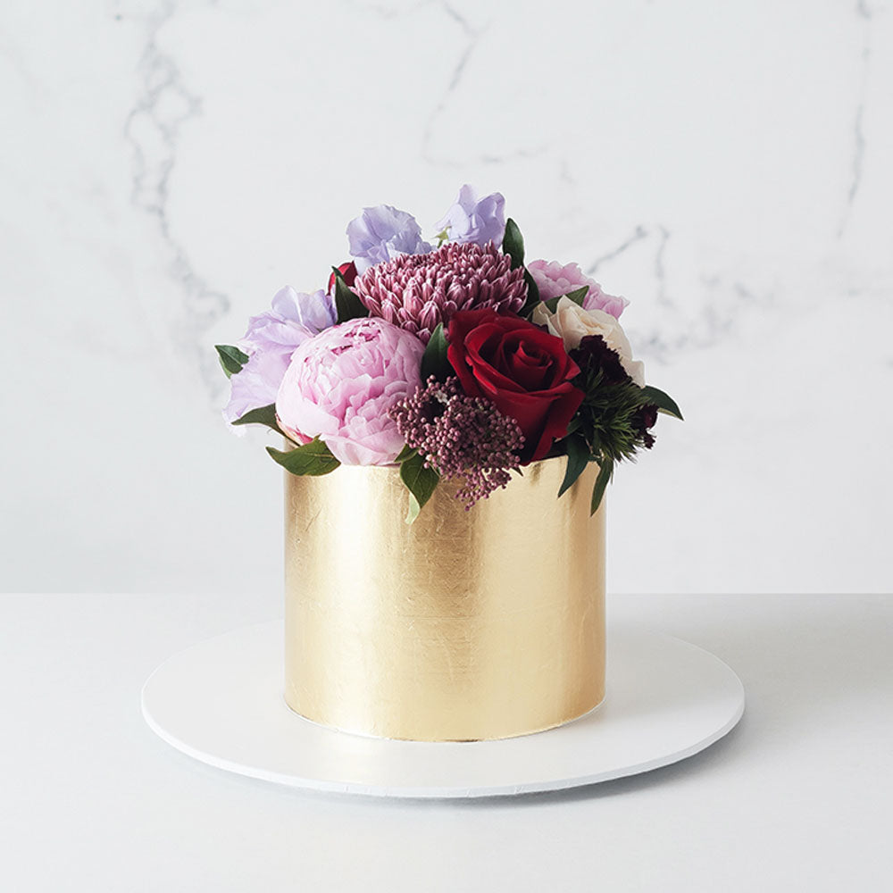 Gold leaf gilded buttercream cake with flowers